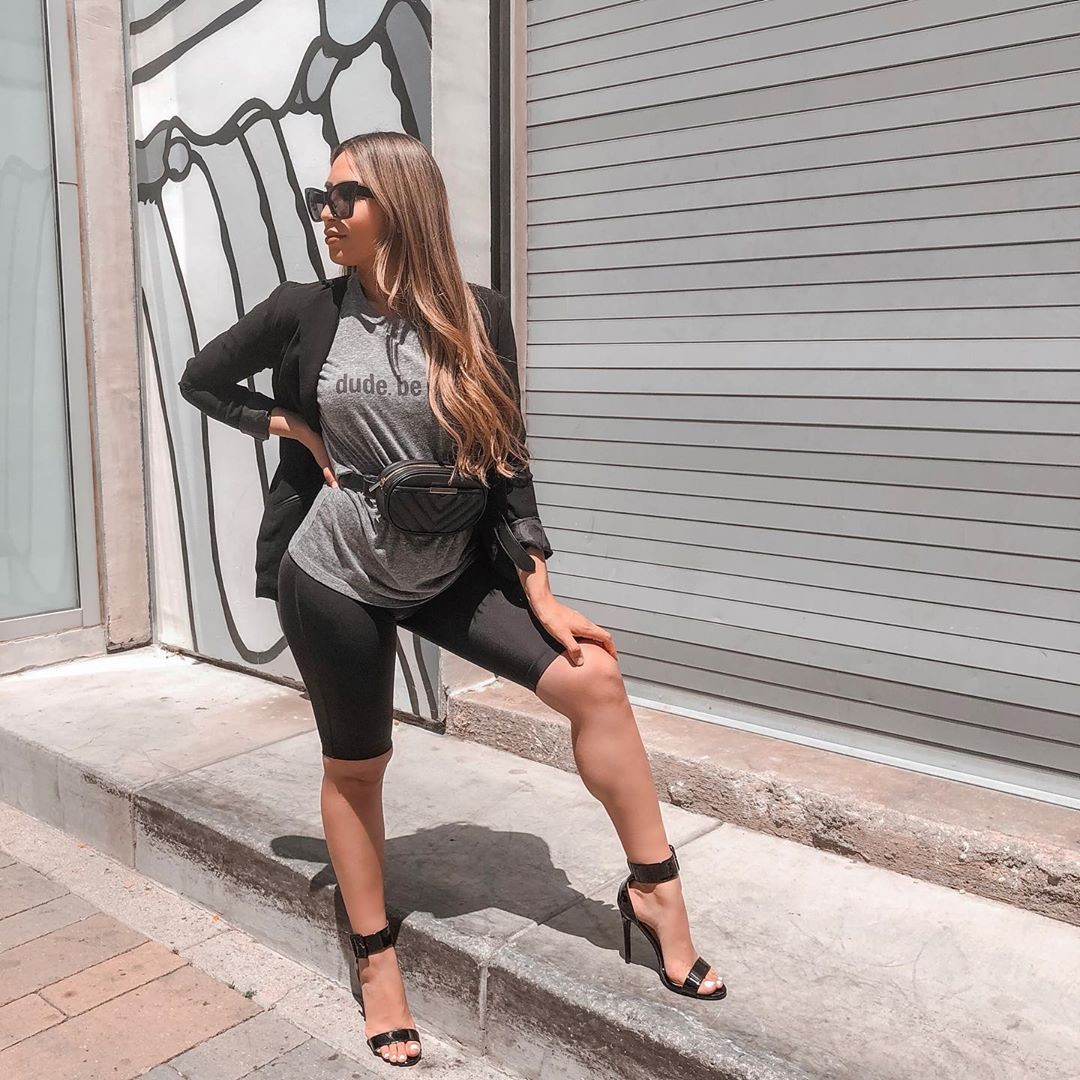 Australian mum wearing SRC postpartum compression shorts styled with grey shirt, blazer, heels, and leather bum bag.