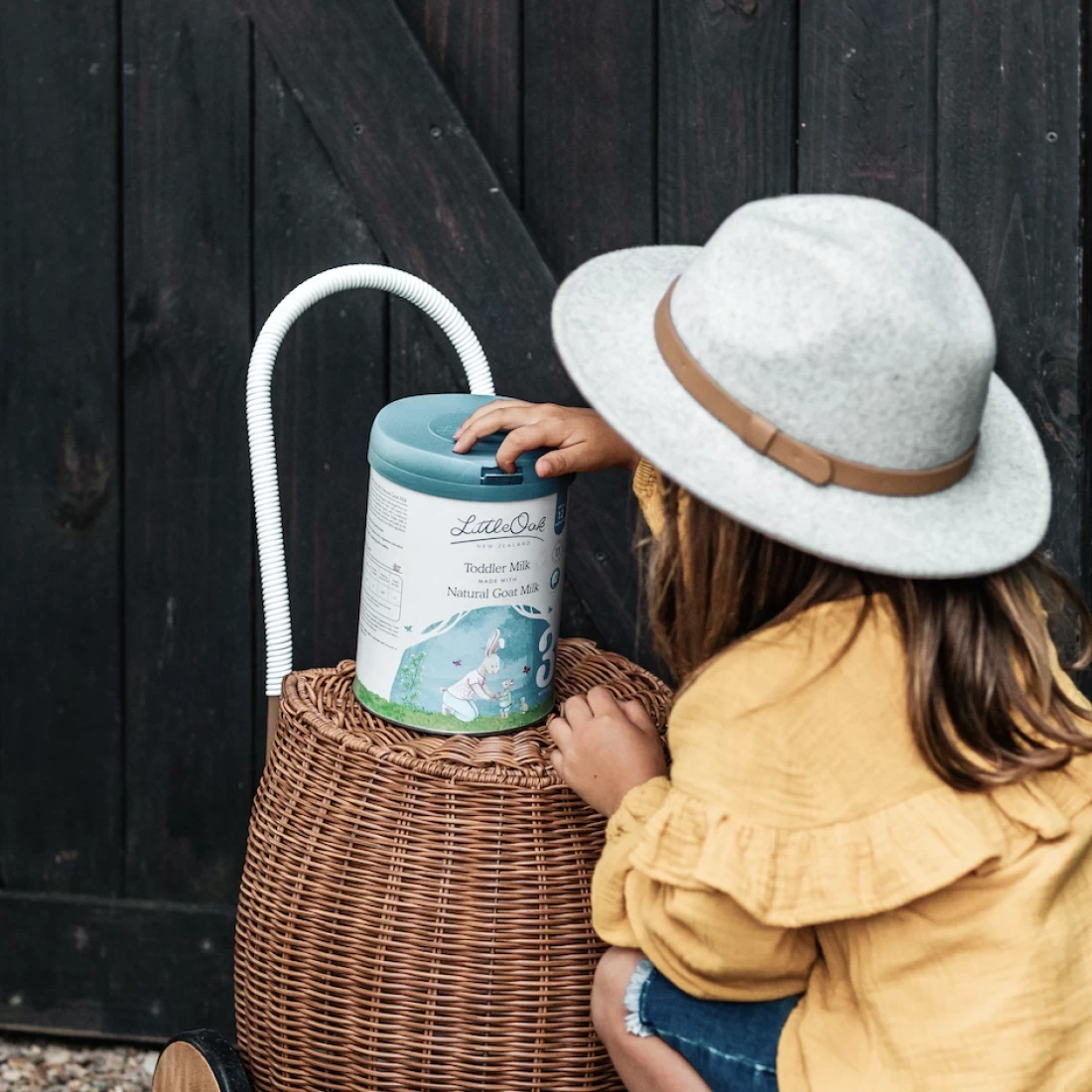 Happy toddler girl holding LittleOak Natural Whole Goat's Milk Formula and Toddler Milk – trusted as the best formula milk for Aussie toddlers.