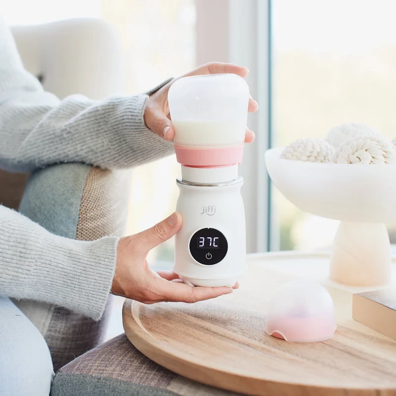 The Jiffi bottle warmer being held by a mum, showing its digital display