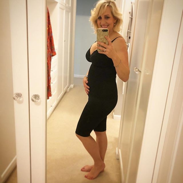 Pregnant mum taking a mirror selfie while wearing compression shorts for support with bump related issues during pregnancy.