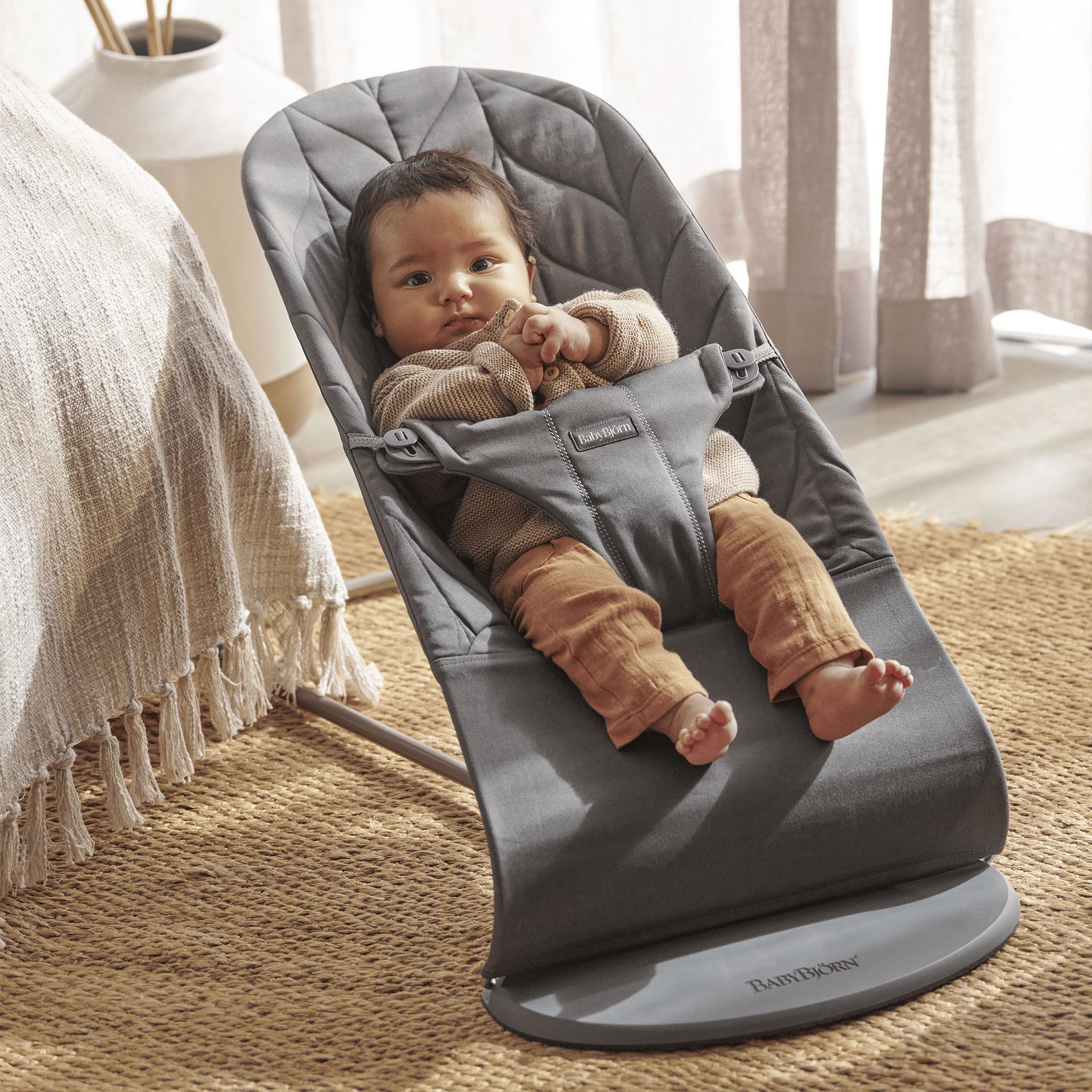 Baby relaxing in the Baby Bjorn baby bouncer in a living room