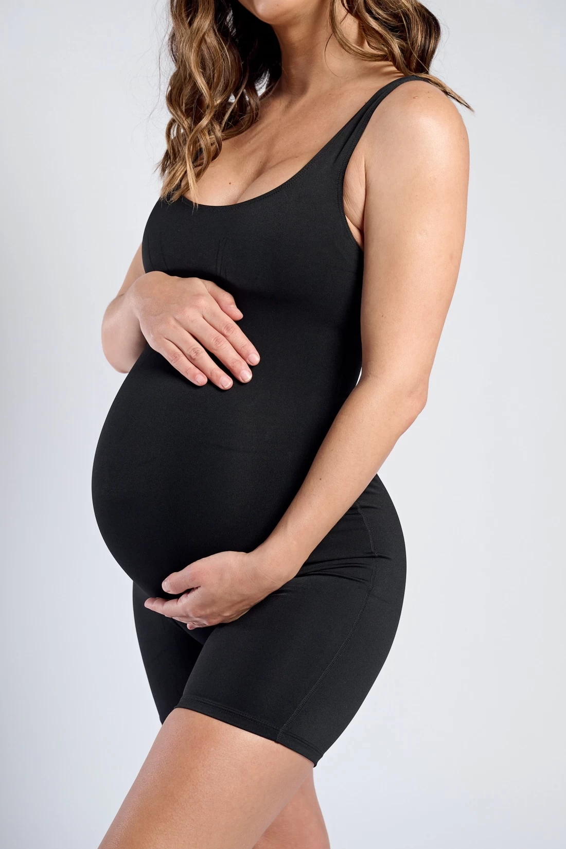 Mum wearing Estroni Tank Bodysuit best maternity activewear against a white background.