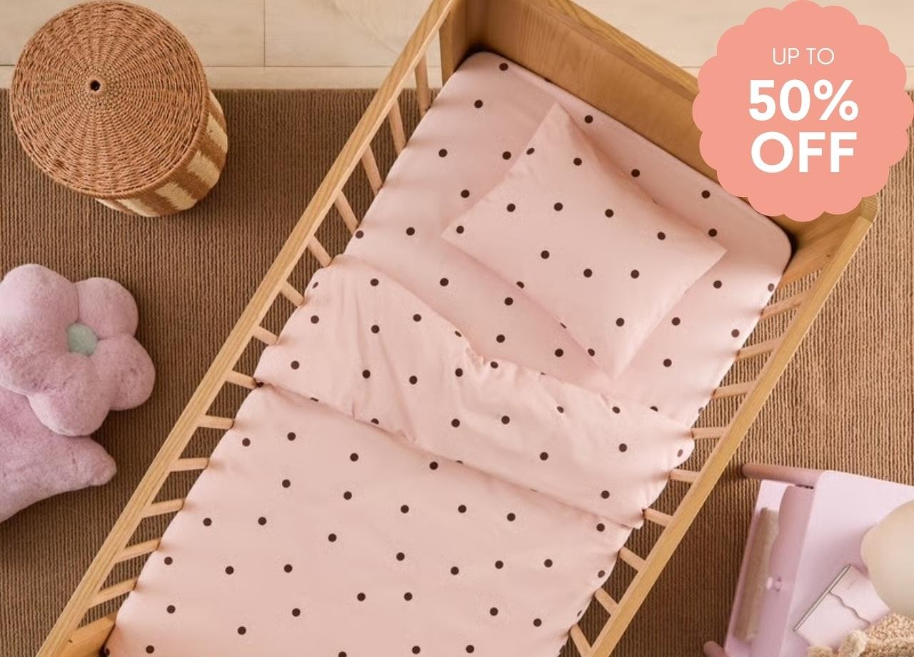 a pola dot cot sheet on a wooden bed