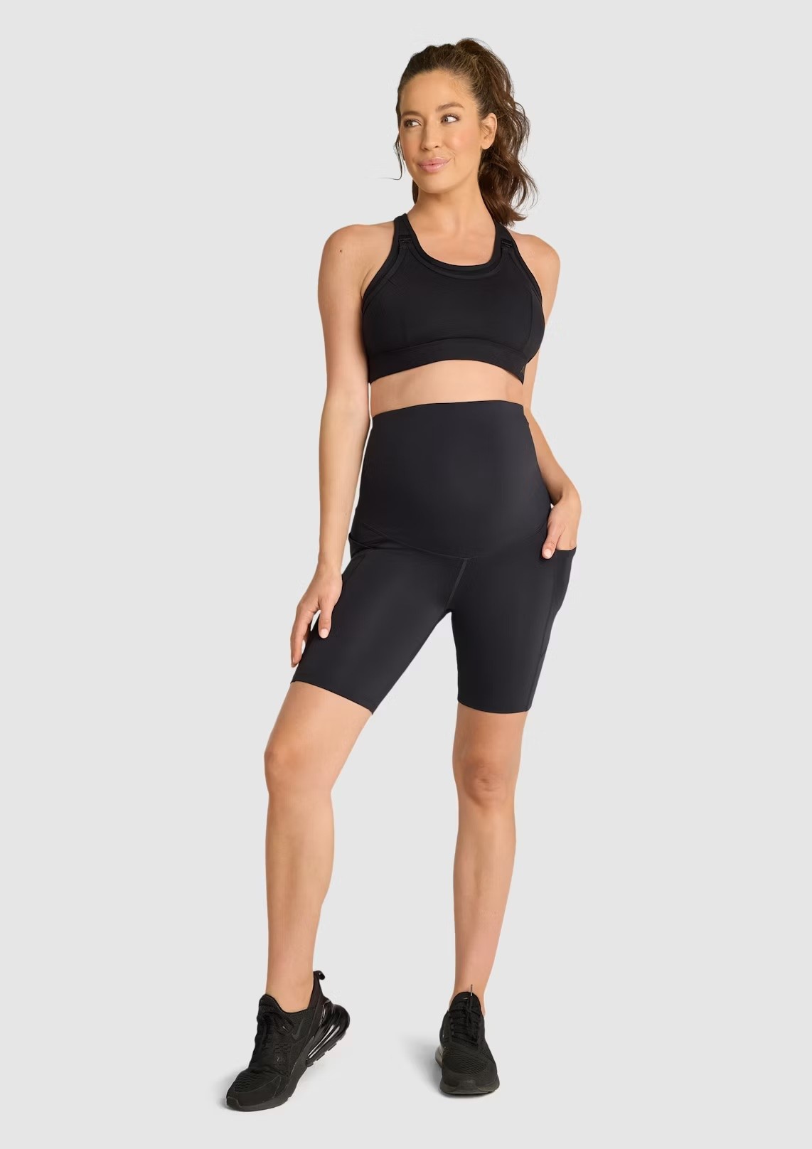 A woman with a ponytail wearing Rockwear's maternity bike shorts