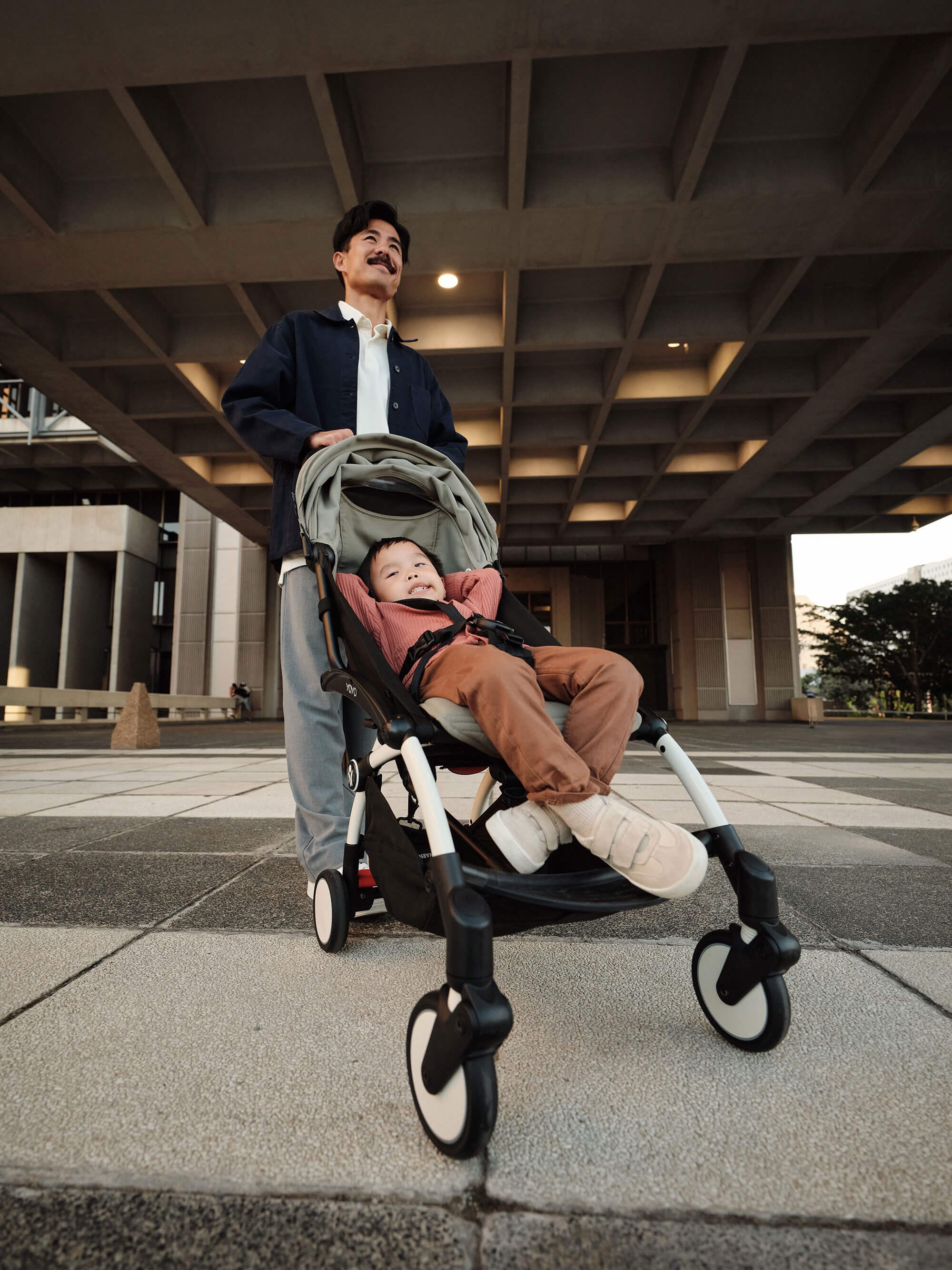 Active dad pushing the Stokke Yoyo³ Travel Pram on the go with his baby.