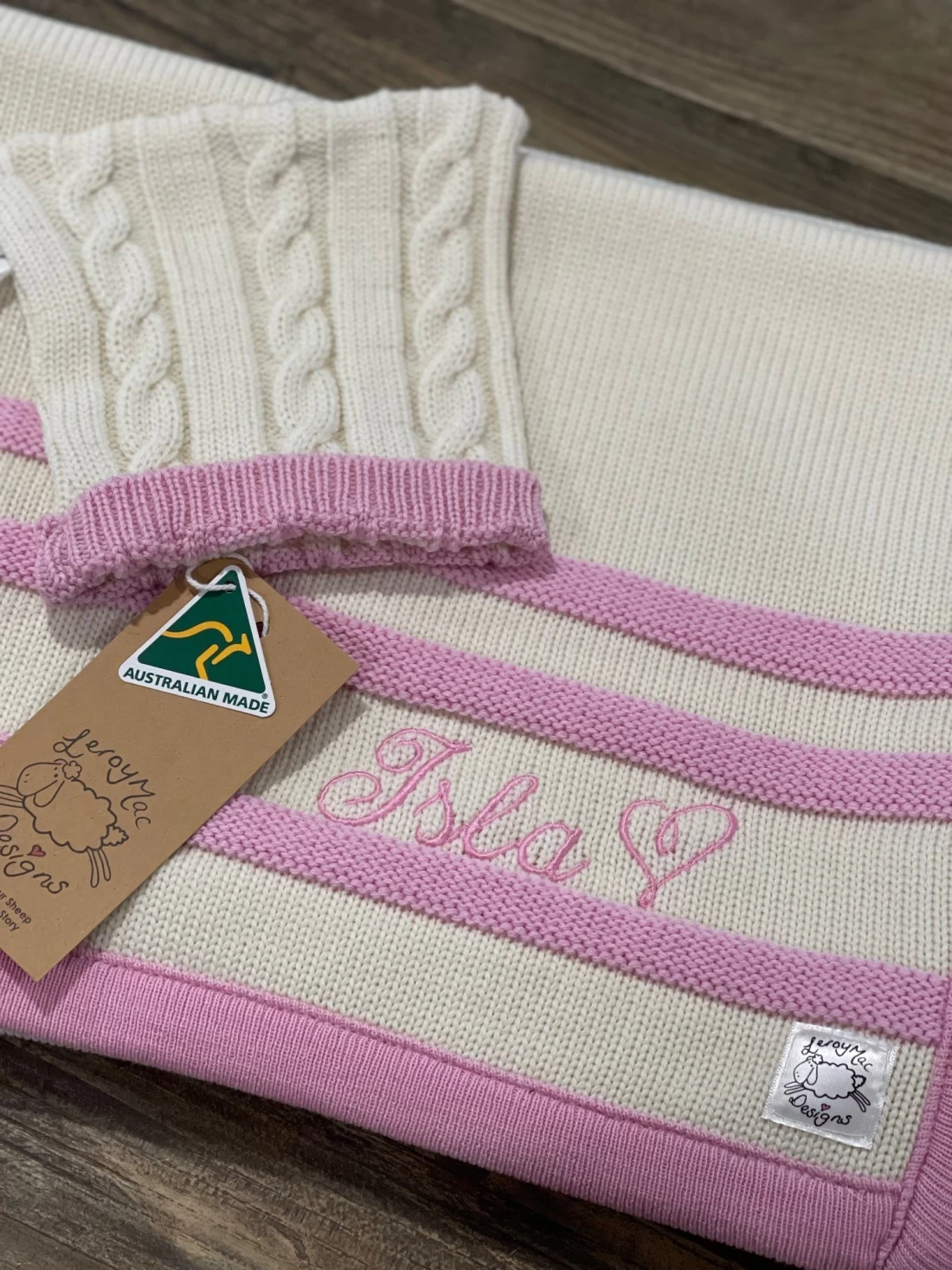 Laid flat merino best baby blanket in white with soft pink detail for newborn comfort.