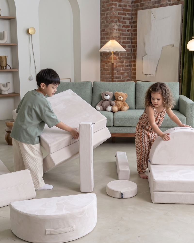 Two children playing creatively with the loungey play couch
