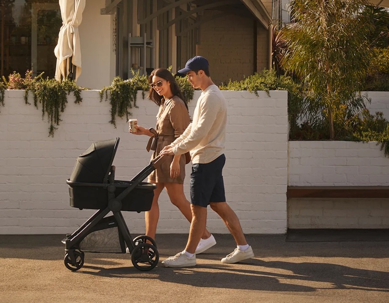 Two parents pushing the Babybee Rover3 with bassinet attachment as a newborn pram