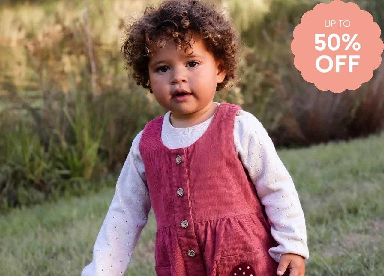 a little girl in pink overalls