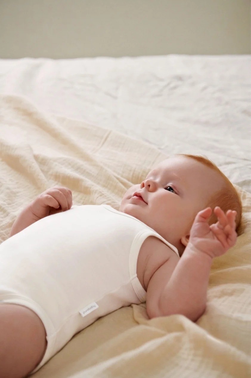 purebaby rib bodysuit on a newborn lying down