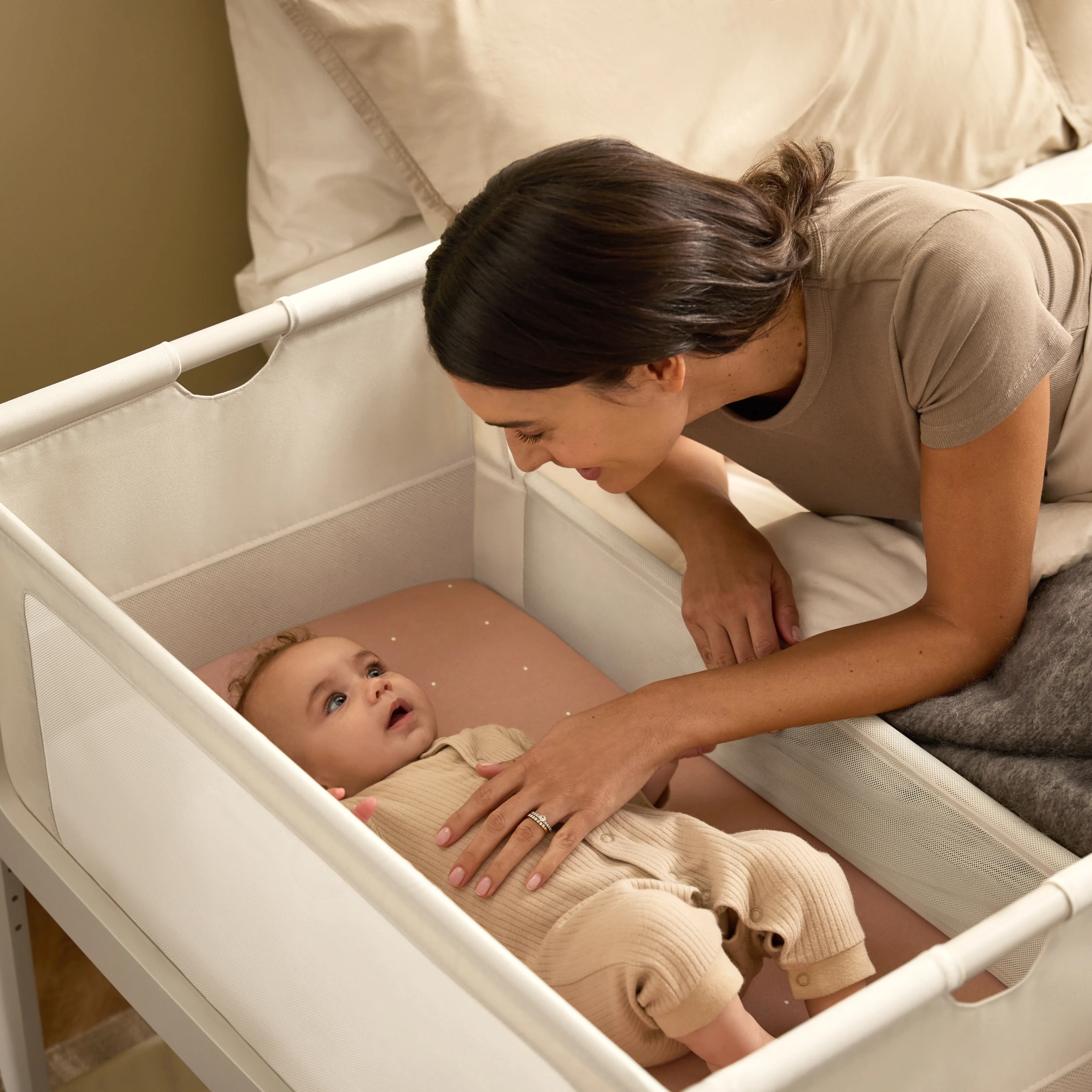 The Snuzpod 5 cosleeper bassinet being used by a mum next to her bed