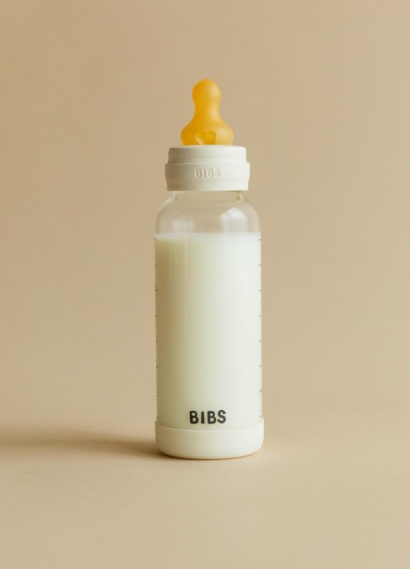 The bibs glass baby bottle shown on a beige backdrop