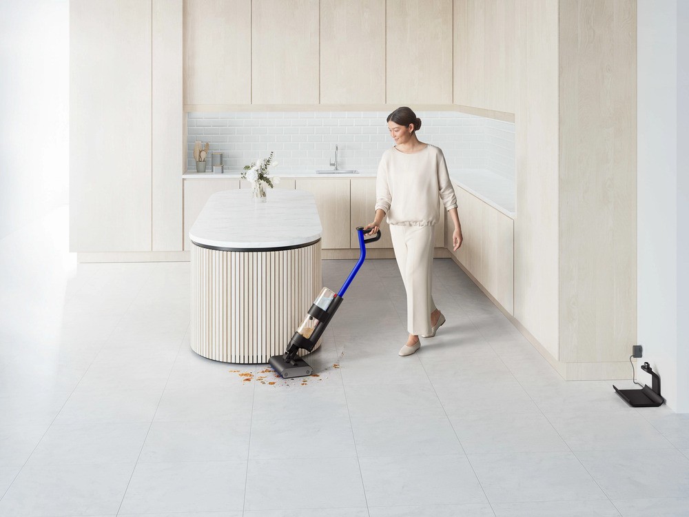 Mother vacuuming floors with a wet vacuum cleaner powered by the best cleaning product