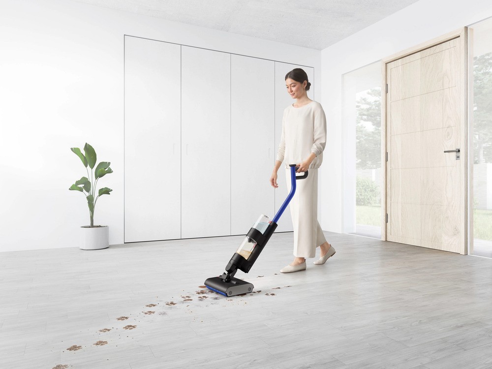 Mum cleaning the floor with a wet vacuum cleaner using the best cleaning product for spotless results.