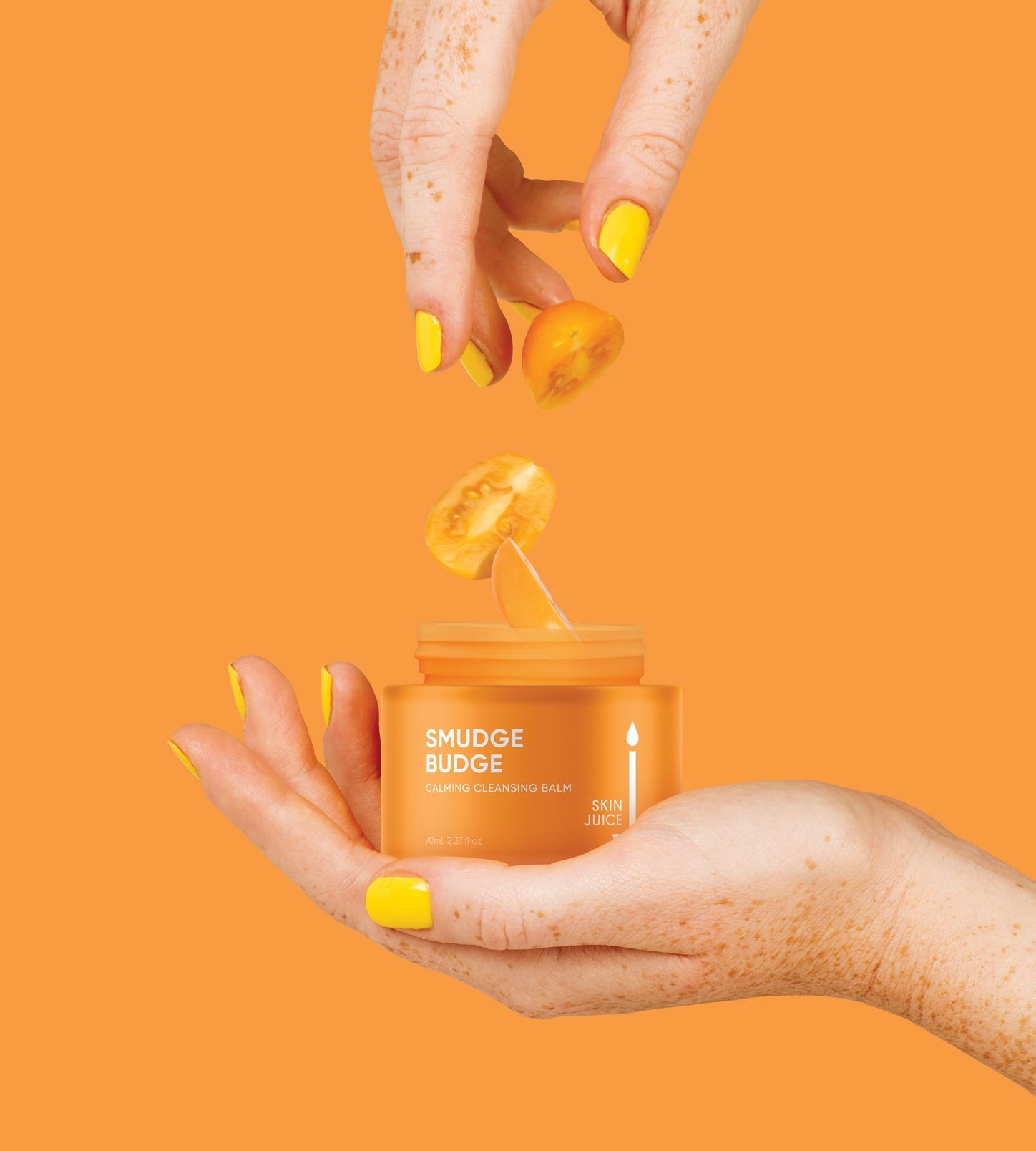 Hand holding Smudge Budge Calming Cleansing Balm against yellow backdrop for pregnancy skin condition care.