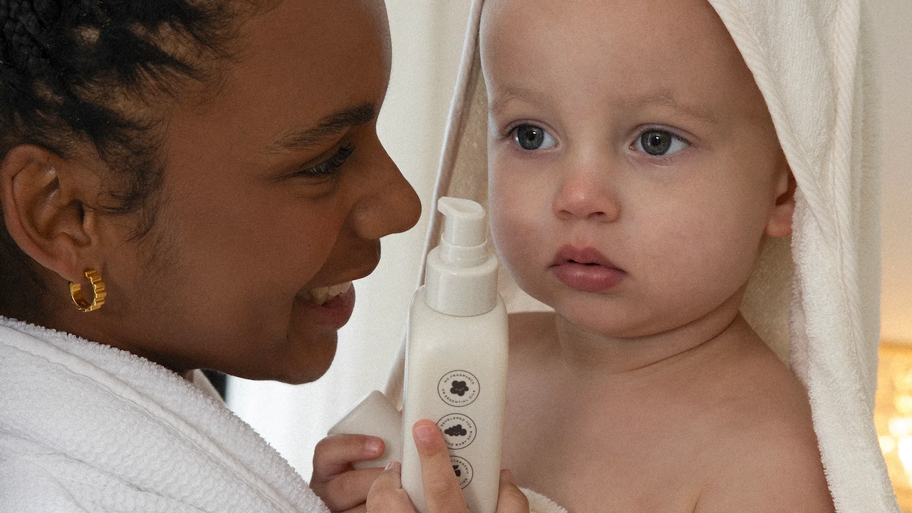A baby holding Veeore baby eczema skincare with its mother