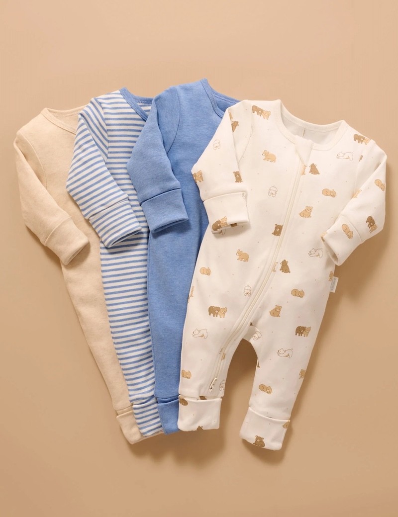 four organic cotton zip growsuits by purebaby layered on top of each other