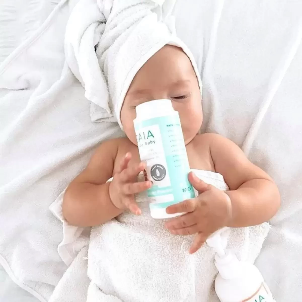a baby holding some baby skincare