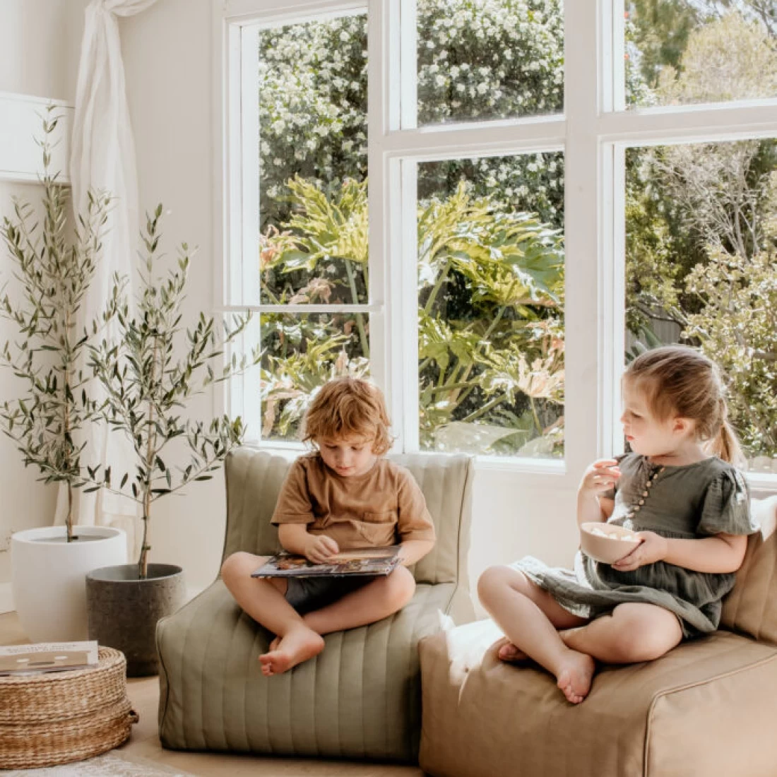 Two happy kids enjoying books on beanbag loungers, showcasing the best toddler table and chair for cosy seating.
