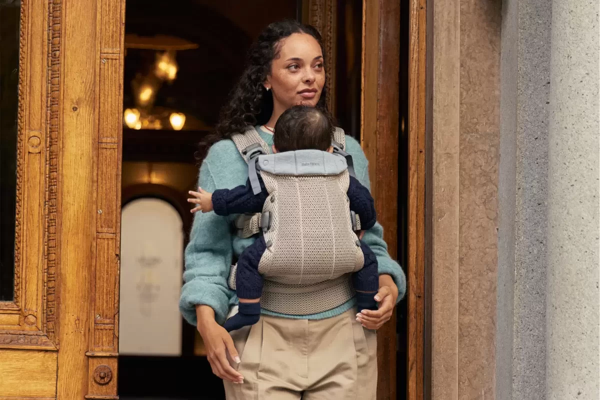 A mum with a baby in a carrier, a great baby registry gift