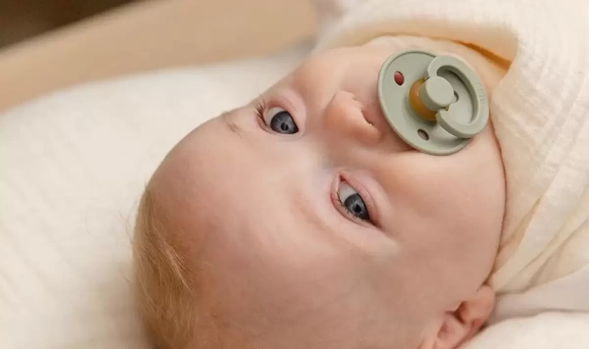 A baby with a dummy in its mouth