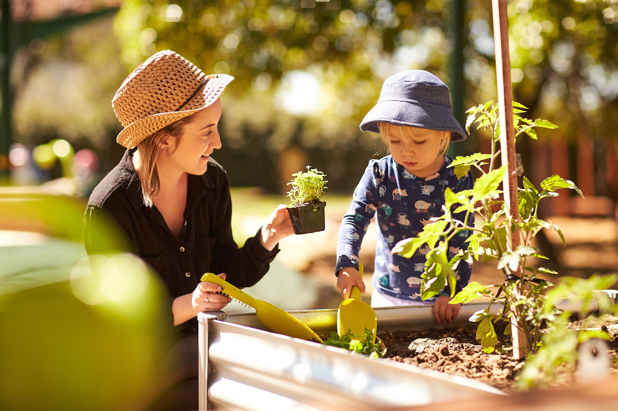 Child engaged in interactive learning through planting with a teacher at the best childcare centre