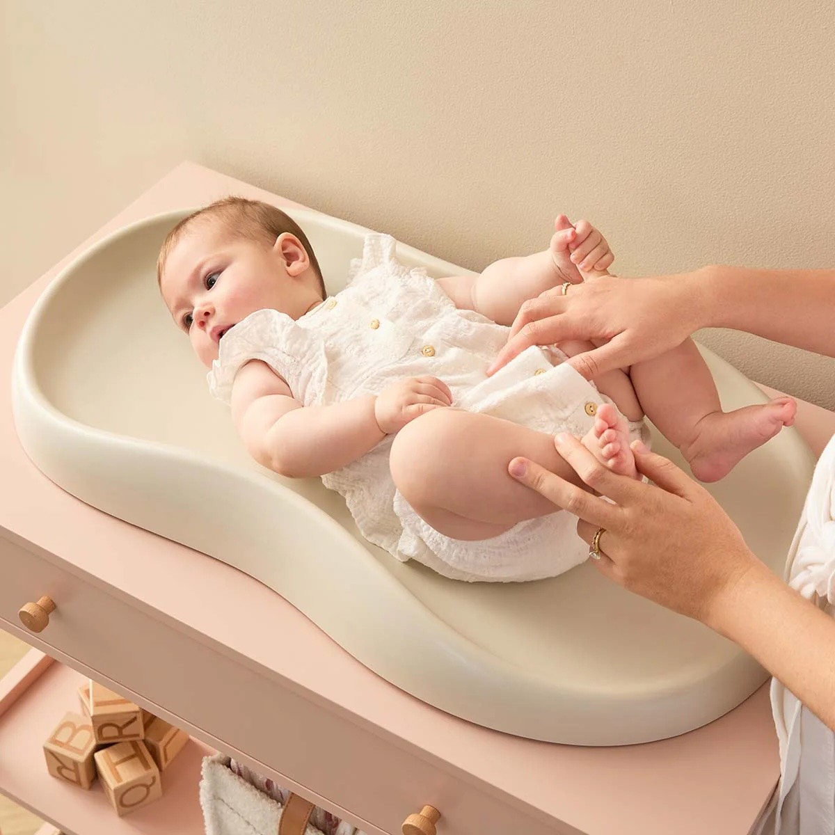 A baby lying on the Mocka baby changing mat on a change table