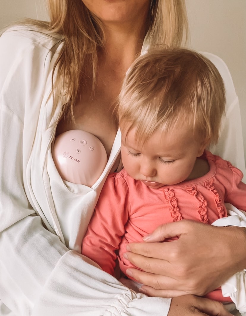 An Australian mother carrying her baby while pumping using the Tyhan Elevate Breast Pump