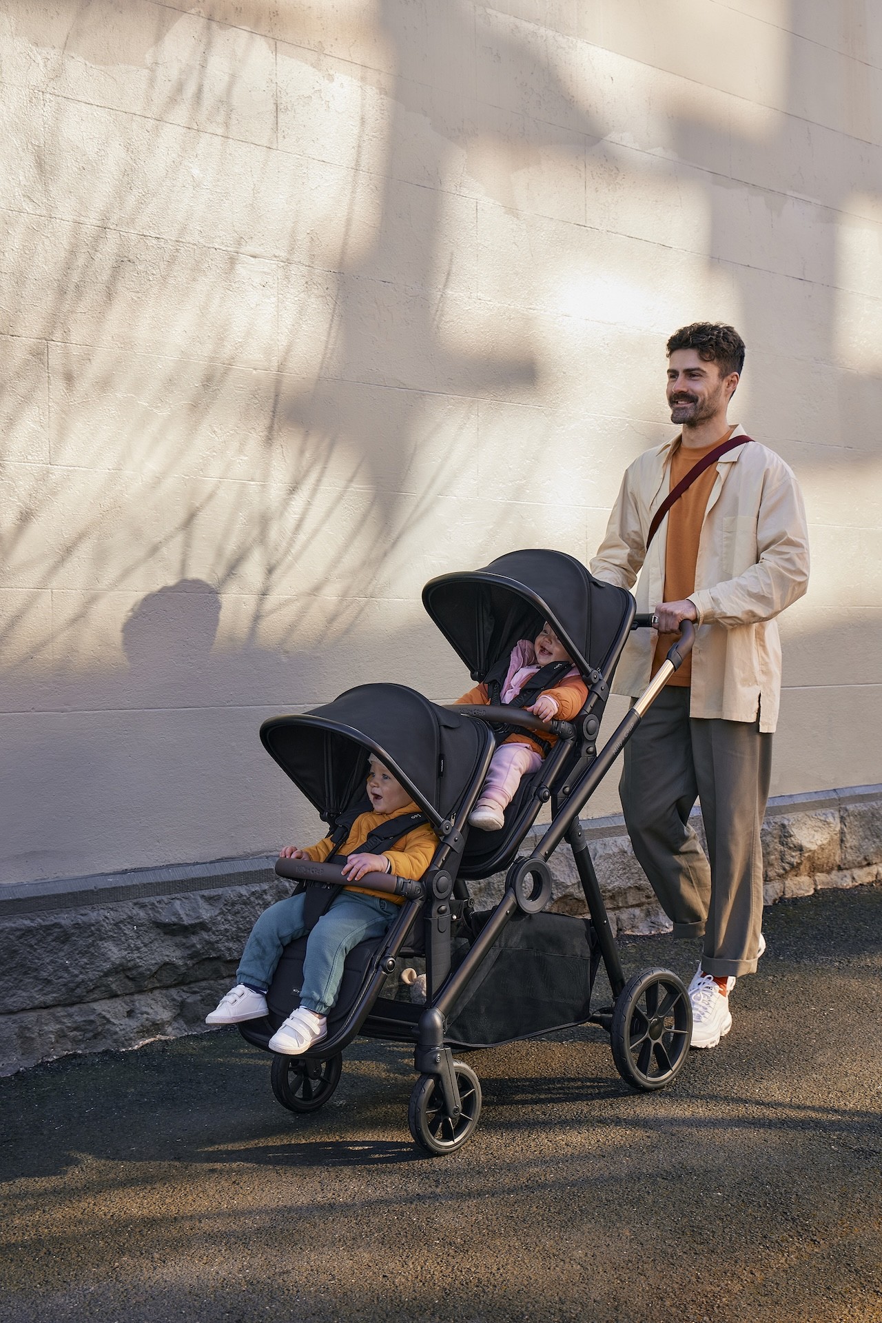 A dad walking his two children in the Milly + Coup Leo affordable pram