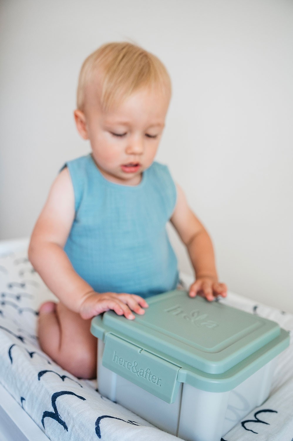 Toddler holding a container of cloth wipes by Here & After – perfect for on-the-go nappy changes.