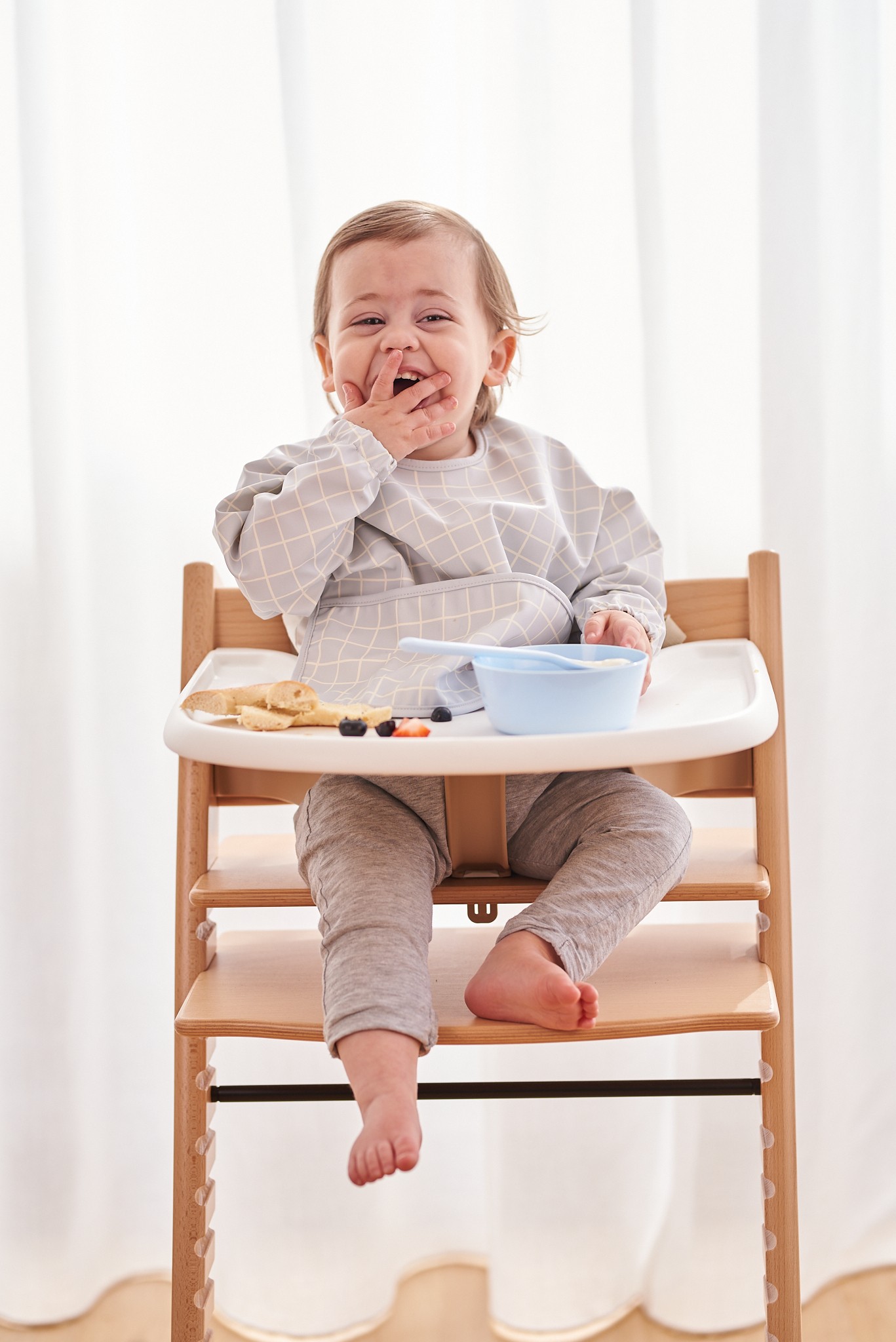 Baby eating comfortably in Jae and Bae Sleeve Bib, the perfect Best Feeding Essential for a tidy mealtime.