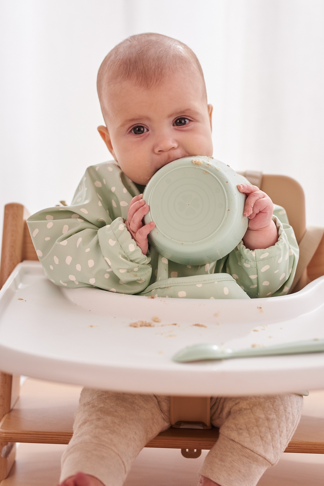 Baby eating while wearing Jae and Bae Sleeve Bib, the Best Feeding Essential for mess-free mealtime