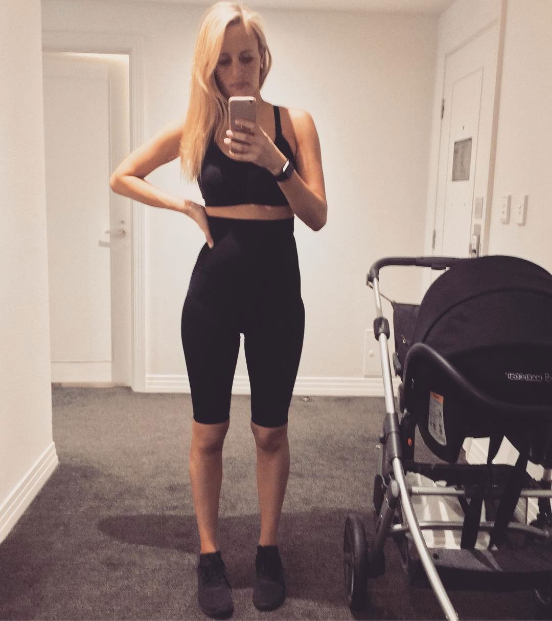 Pregnant mum taking a mirror selfie while wearing black compression shorts designed for comfort and support during pregnancy