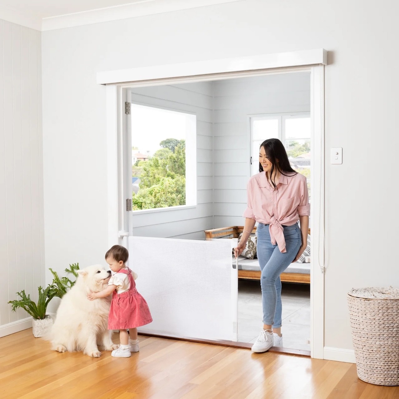 A mum walking through a baby safety gate to greet her child