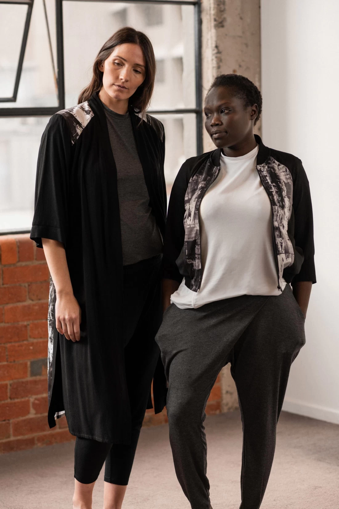 Two mums, one visibly pregnant, wearing stylish Úton maternity clothes for everyday comfort and support.