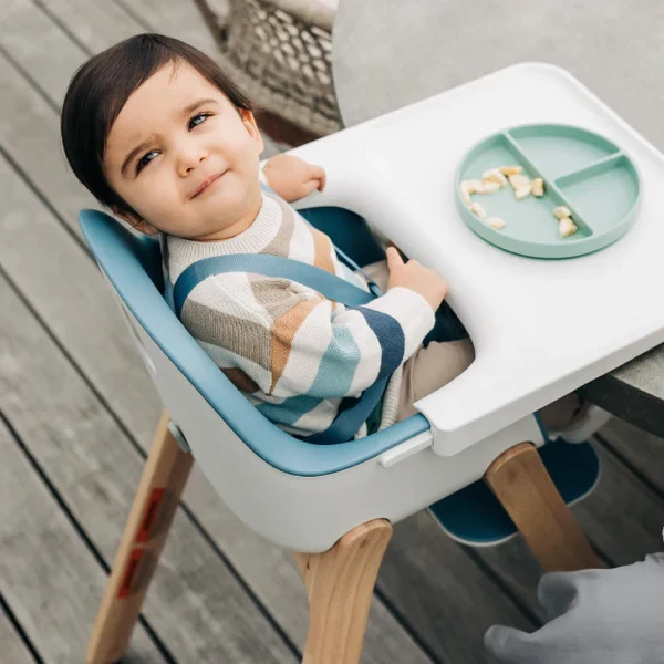 A baby looking at the camera sitting in the Uppababy Ciro High Chair