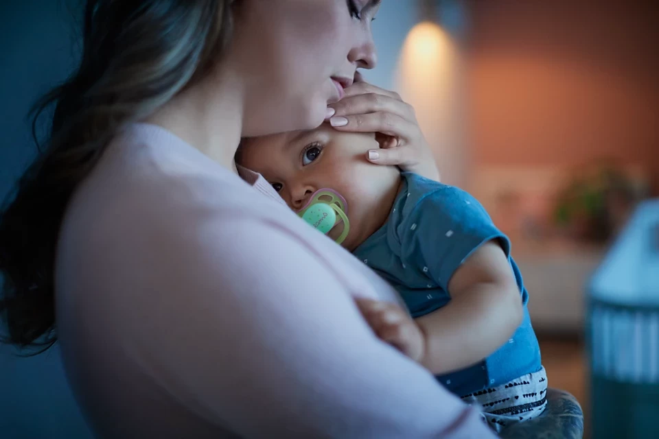A mum soothing her baby,  who is using a Philips Avent Ultra Air dummy in Australia