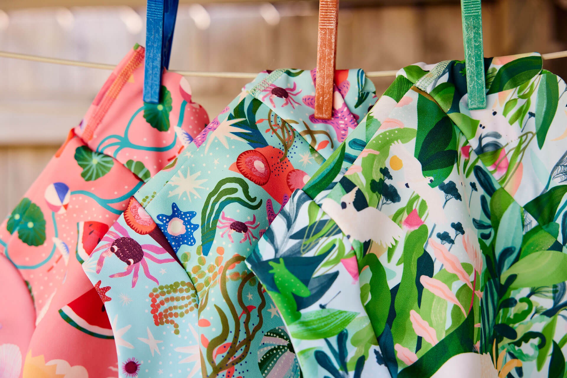 Lil Dippers swim nappies hanging on a clothesline with clothespins, showcasing reusable best swim nappies for babies.