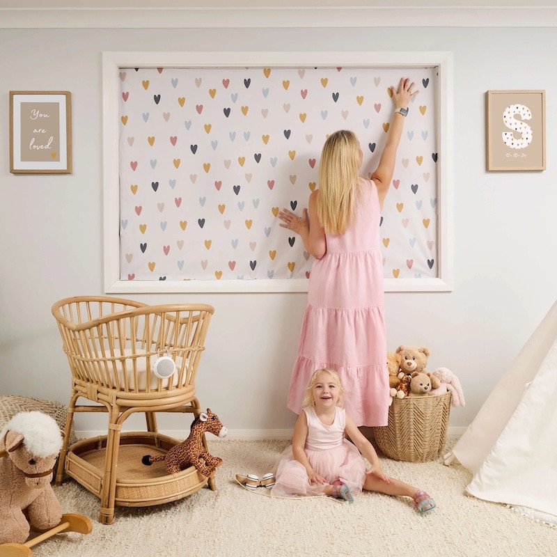 A mum putting up the porta fox blackout blinds in a baby room