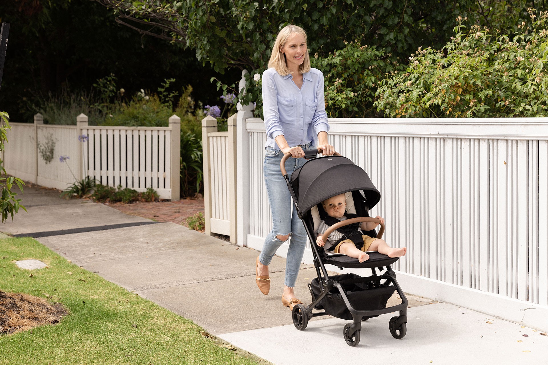 Mum pushing the Babybee MILES, the best travel pram as her baby rides in it during a stroll through the neighbourhood