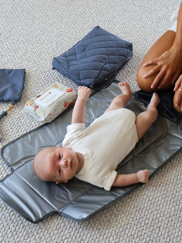 A baby lying on the Sabe Bebe travel change mat