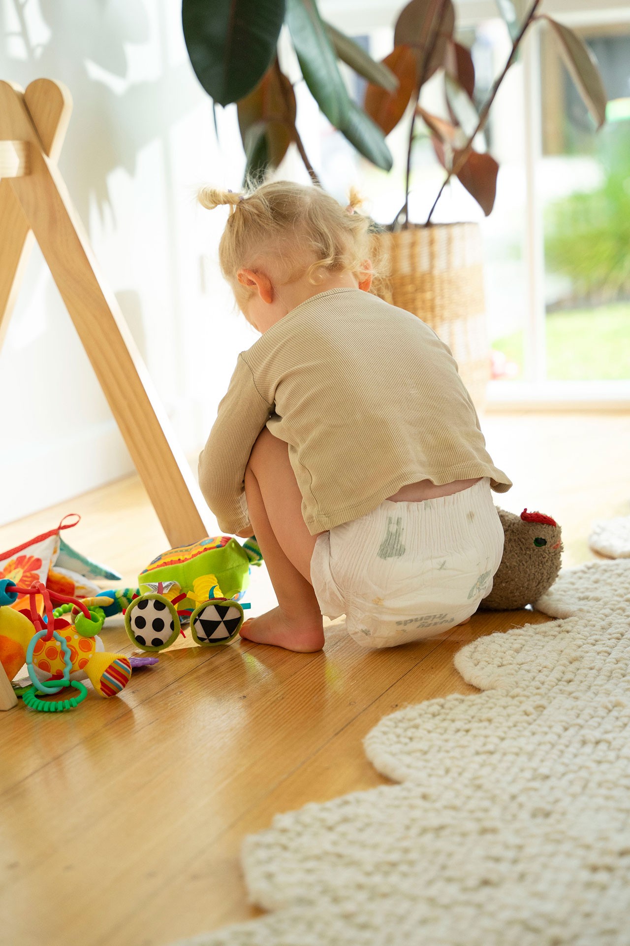 A girl wearing one of the best newborn nappies, playing her soft toys