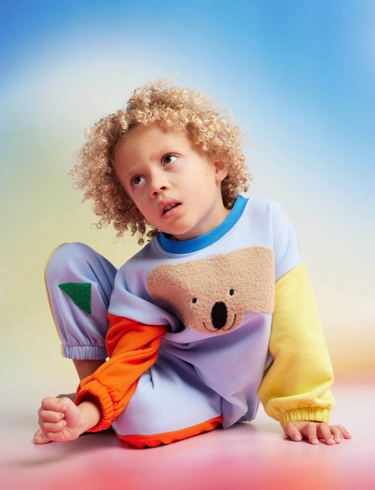 A little boy wearing Halcyon Nights baby clothing tracksuit