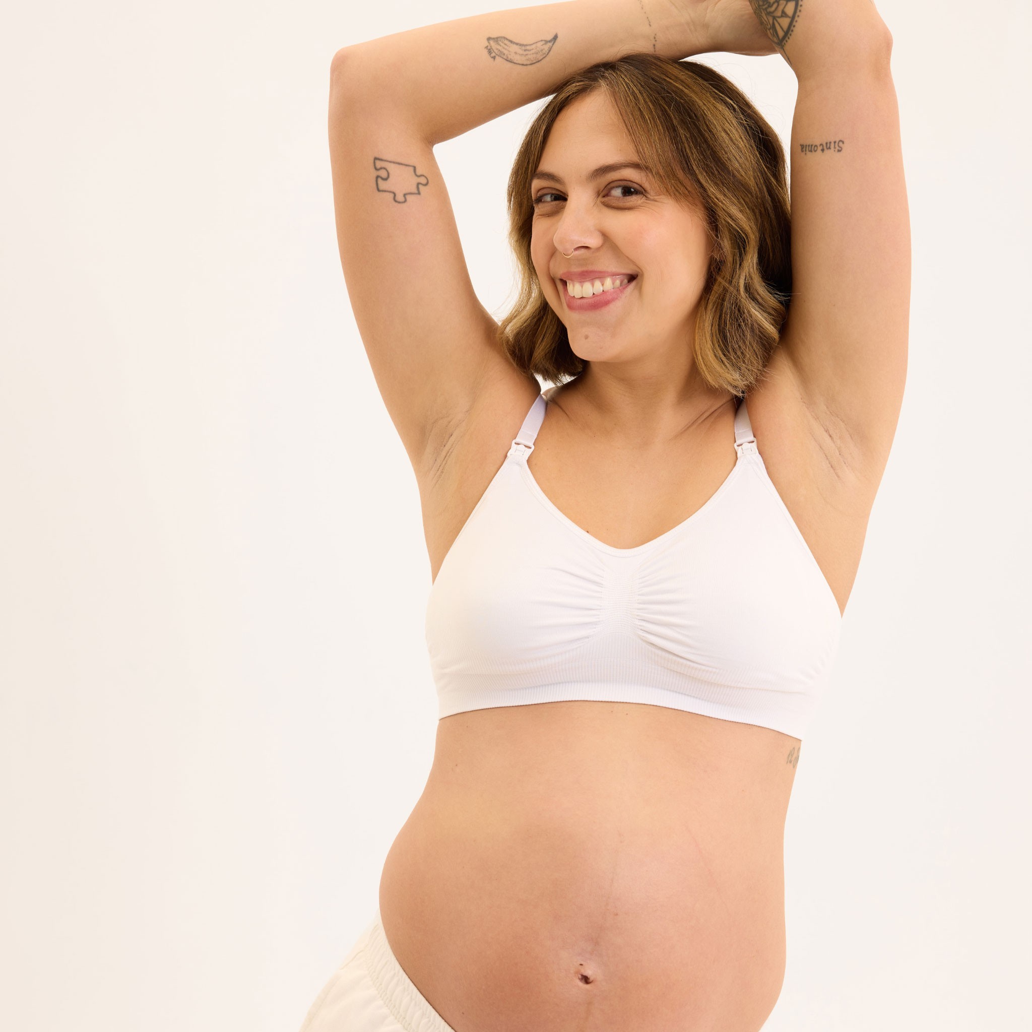 New mum wearing the best maternity bra Australia in white with one handed nursing clips for easy night feeds