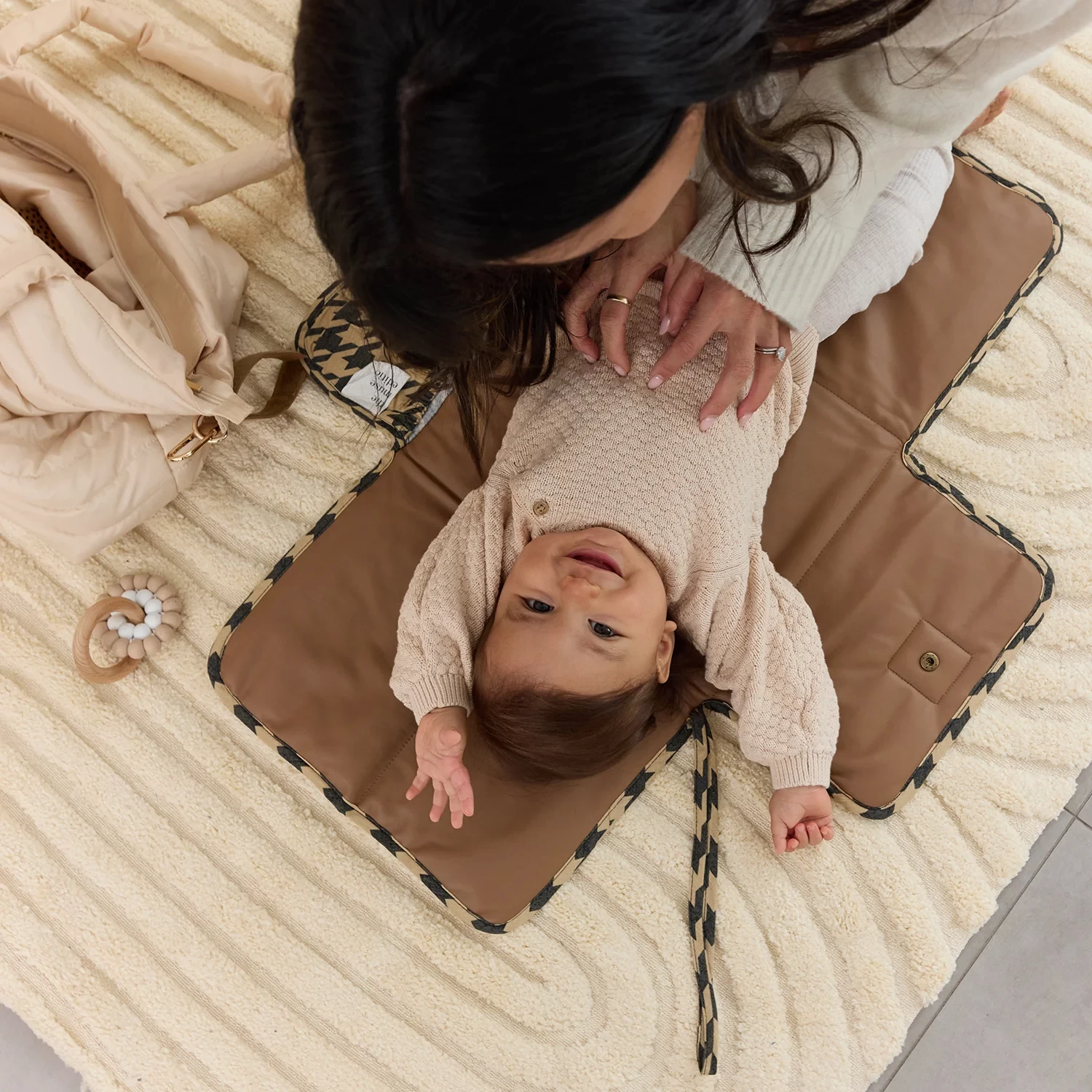A baby lying on a muse society portable change mat