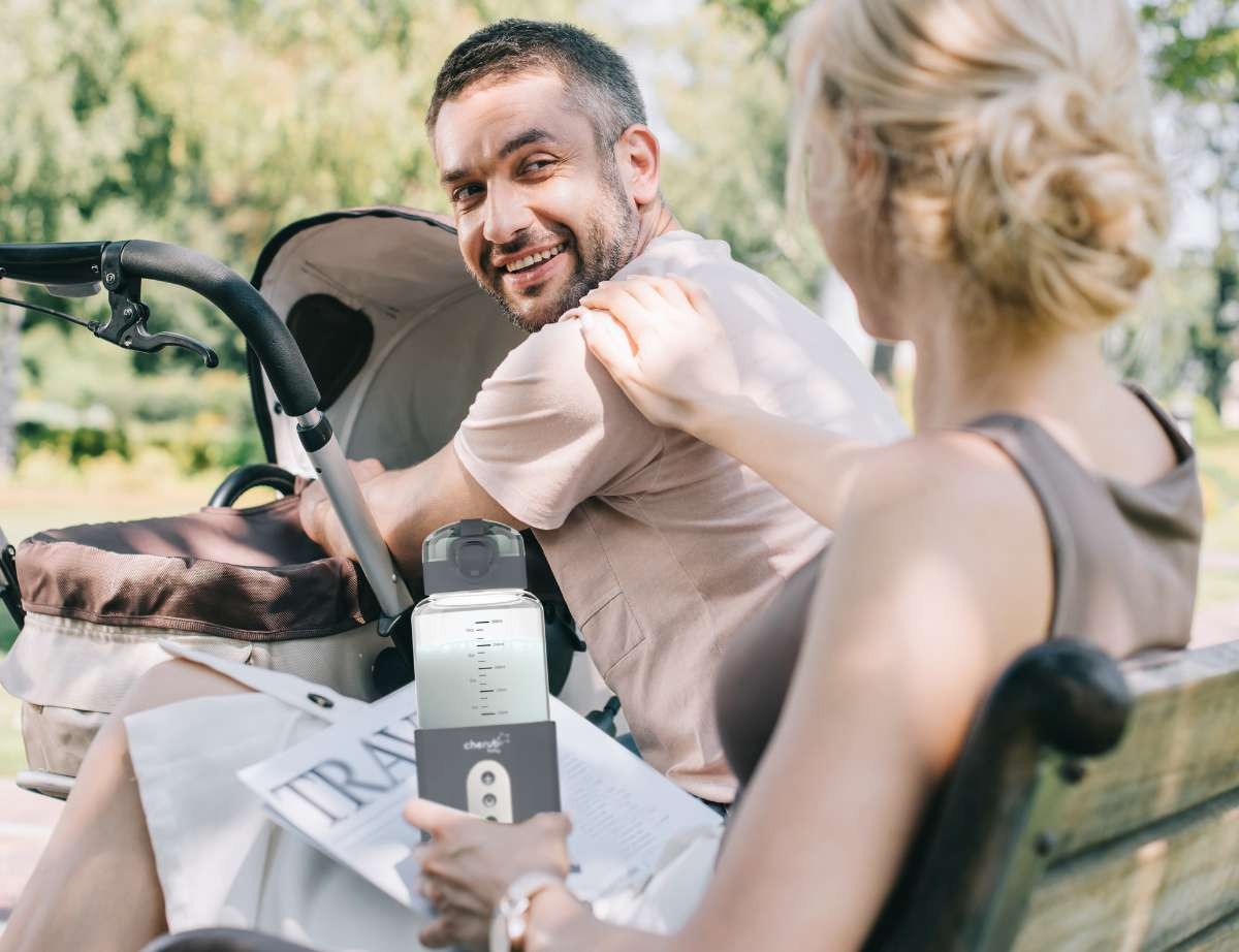 a mum using the cherub baby bottle warmer as a dad tends to the baby