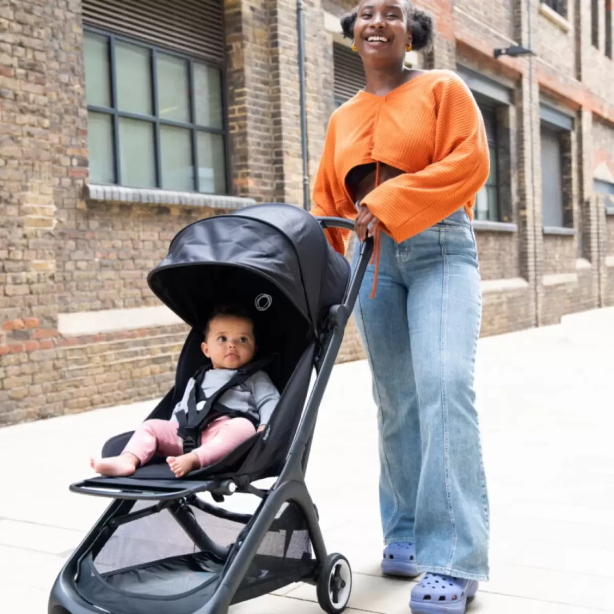 Mum pushing her baby in the Bugaboo butterfly travel pram – the best travel pram for stylish, comfortable journeys.