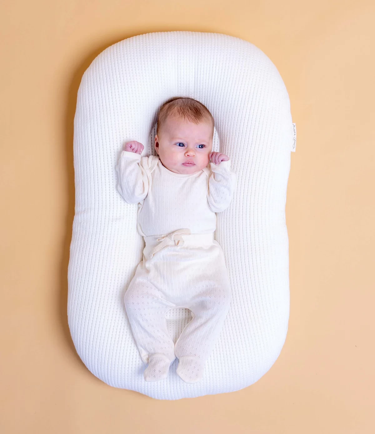 The Bubba Cloud baby lounger shown with a baby lying on it