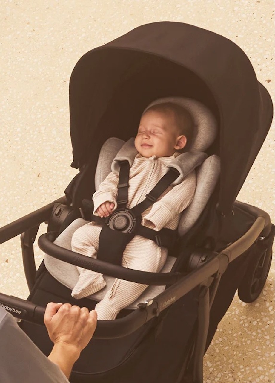 A baby in the Babybee Alto pram, showing the newborn insert