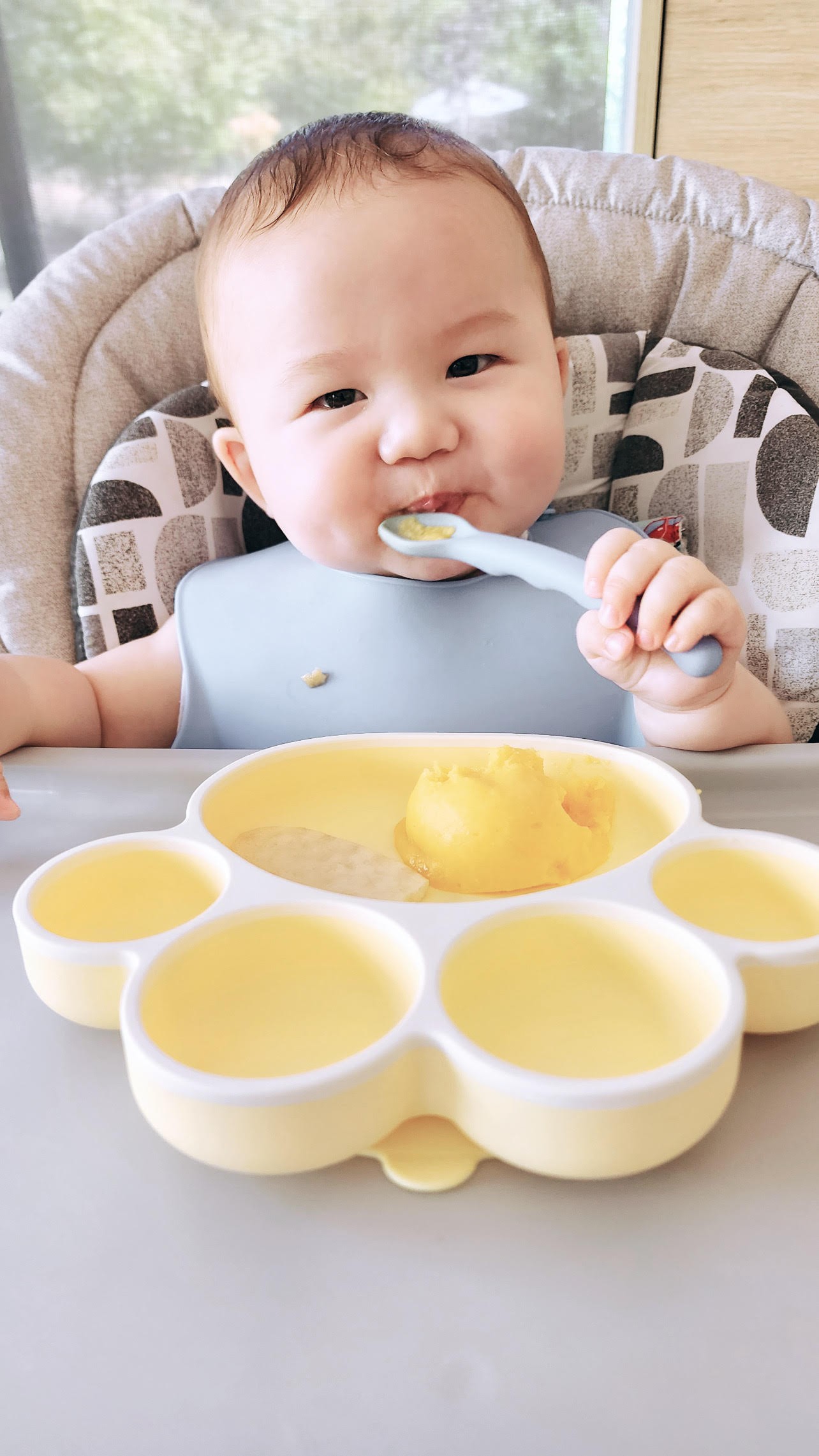 Baby eating in My Pure Silicone Suction Plate, the ideal Best Feeding Essential for keeping mealtime tidy and fun.
